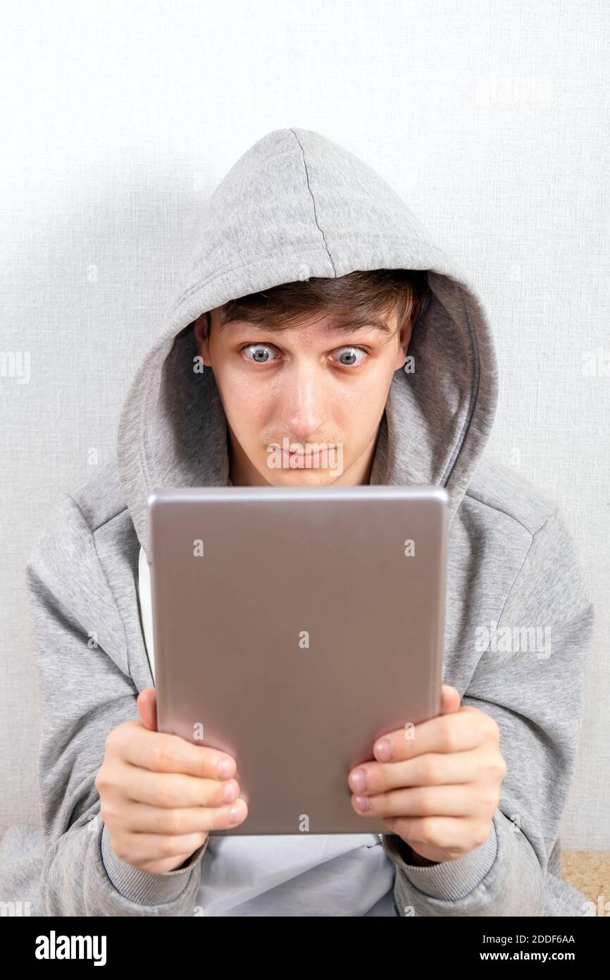 Surprised Young Man with a Tablet Computer on the White Background Stock Photo
