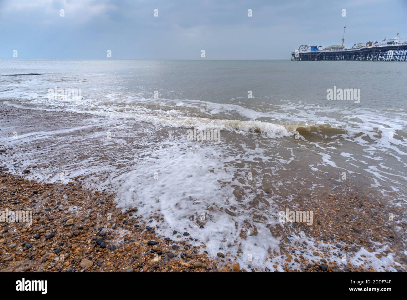 he iconic Victorian pleasure pier,symbolic of the city juts out into the English channel as the sun tries to poke through the wintery sky above. Stock Photo