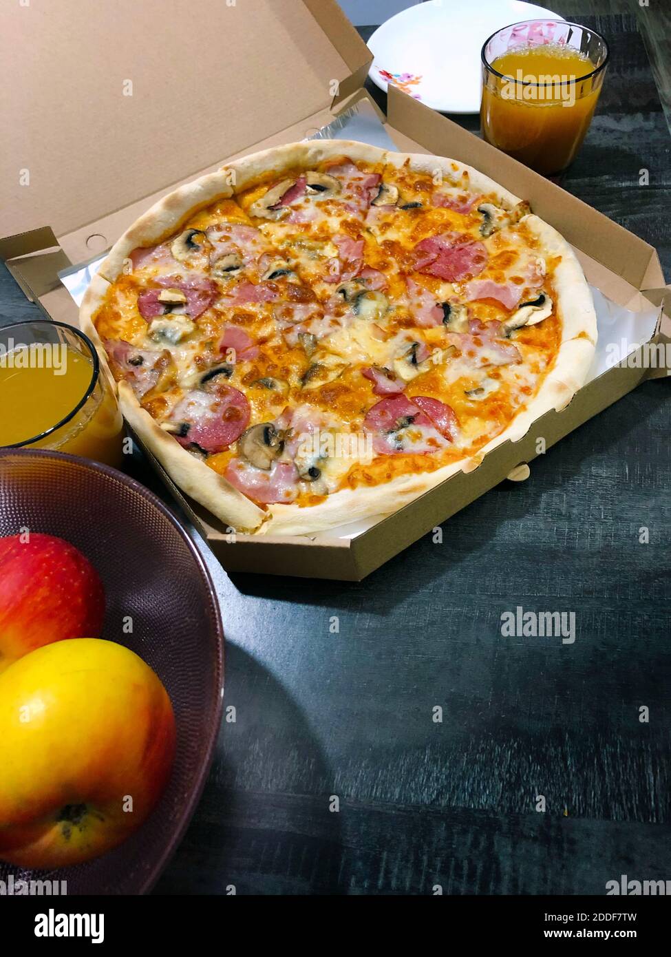 Package box with Pizza, apples and plates on a table, top view. Concept  delivery and take away during a pandemic Stock Photo - Alamy