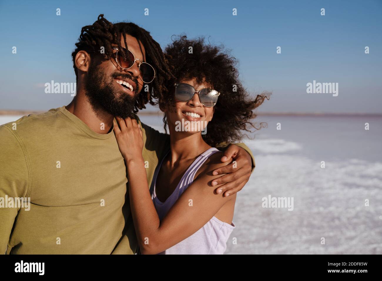 Image of happy african american couple laughing and hugging while ...