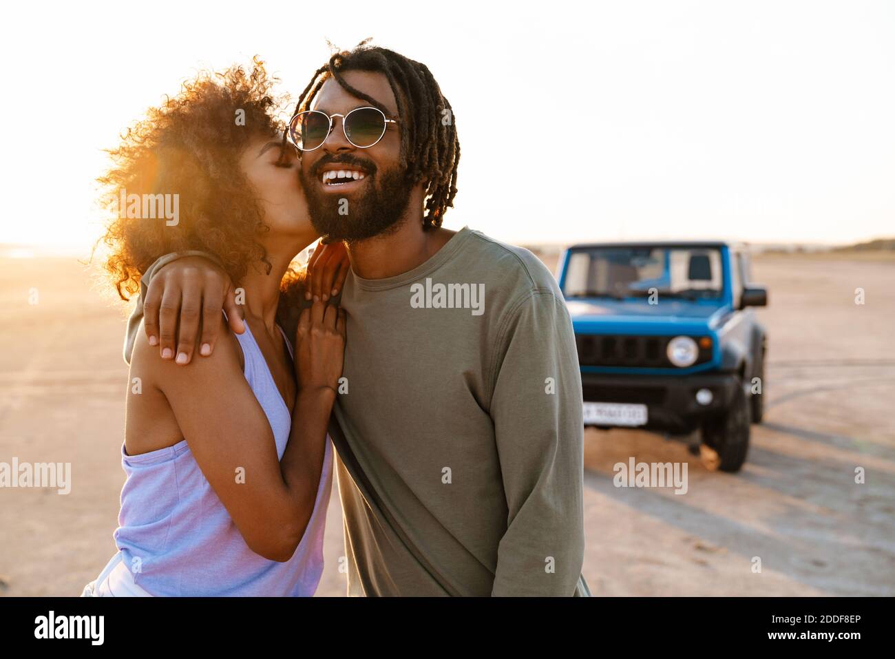 Image of happy african american couple hugging and kissing while ...