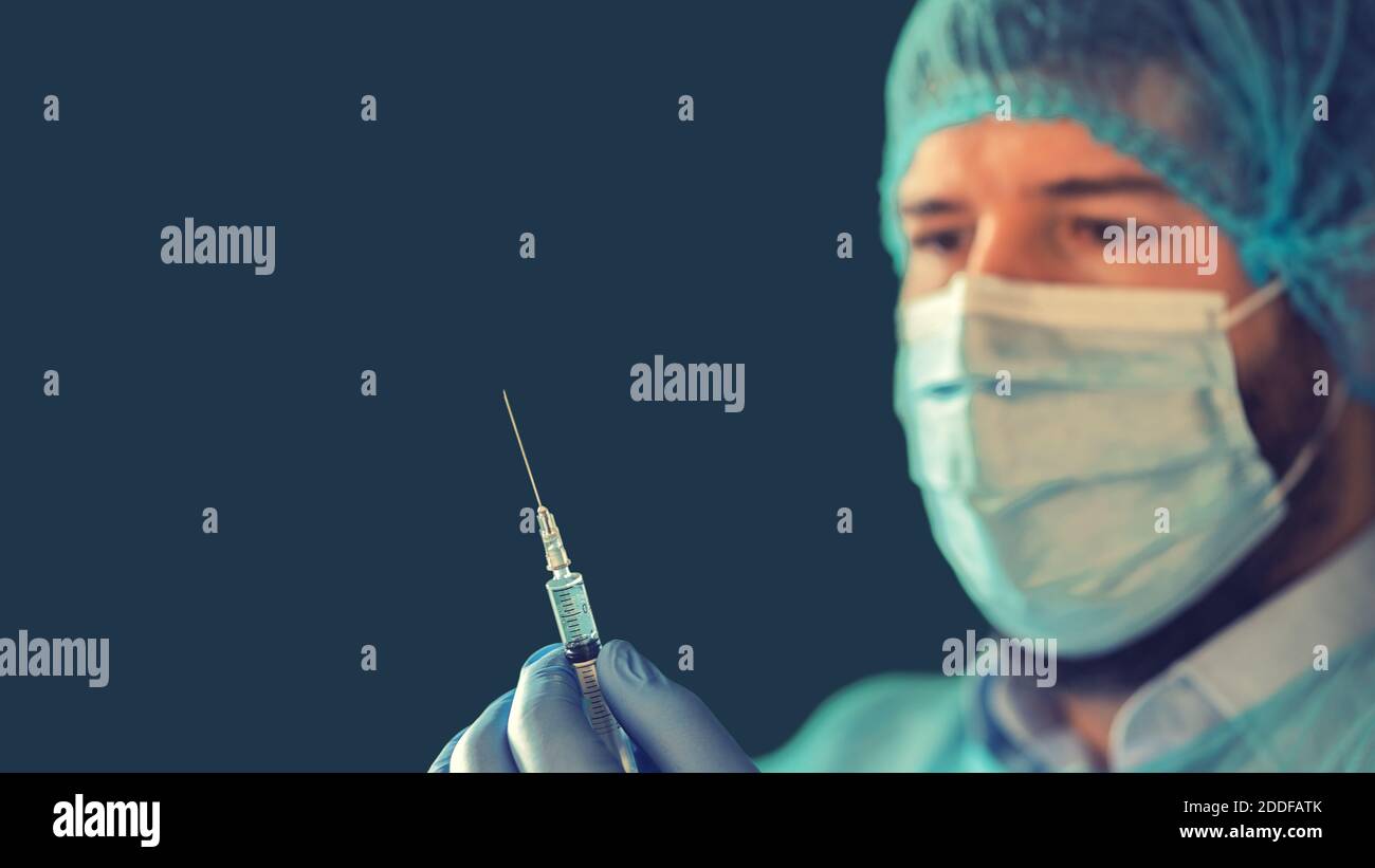Doctor holding experimental vaccine syringe for covid-19 virus Stock Photo