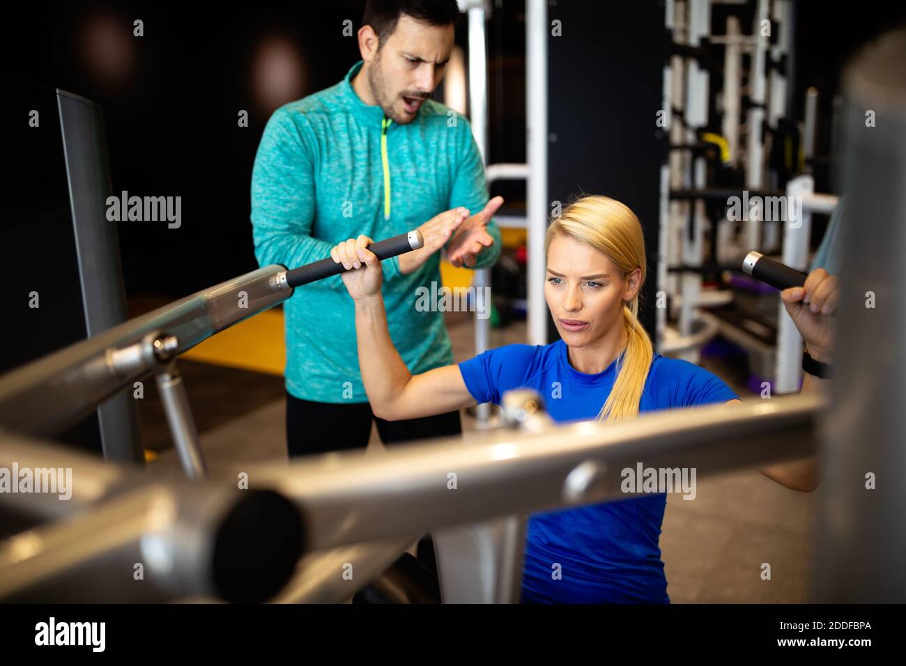 Woman with her personal fitness trainer in the gym exercising Stock ...