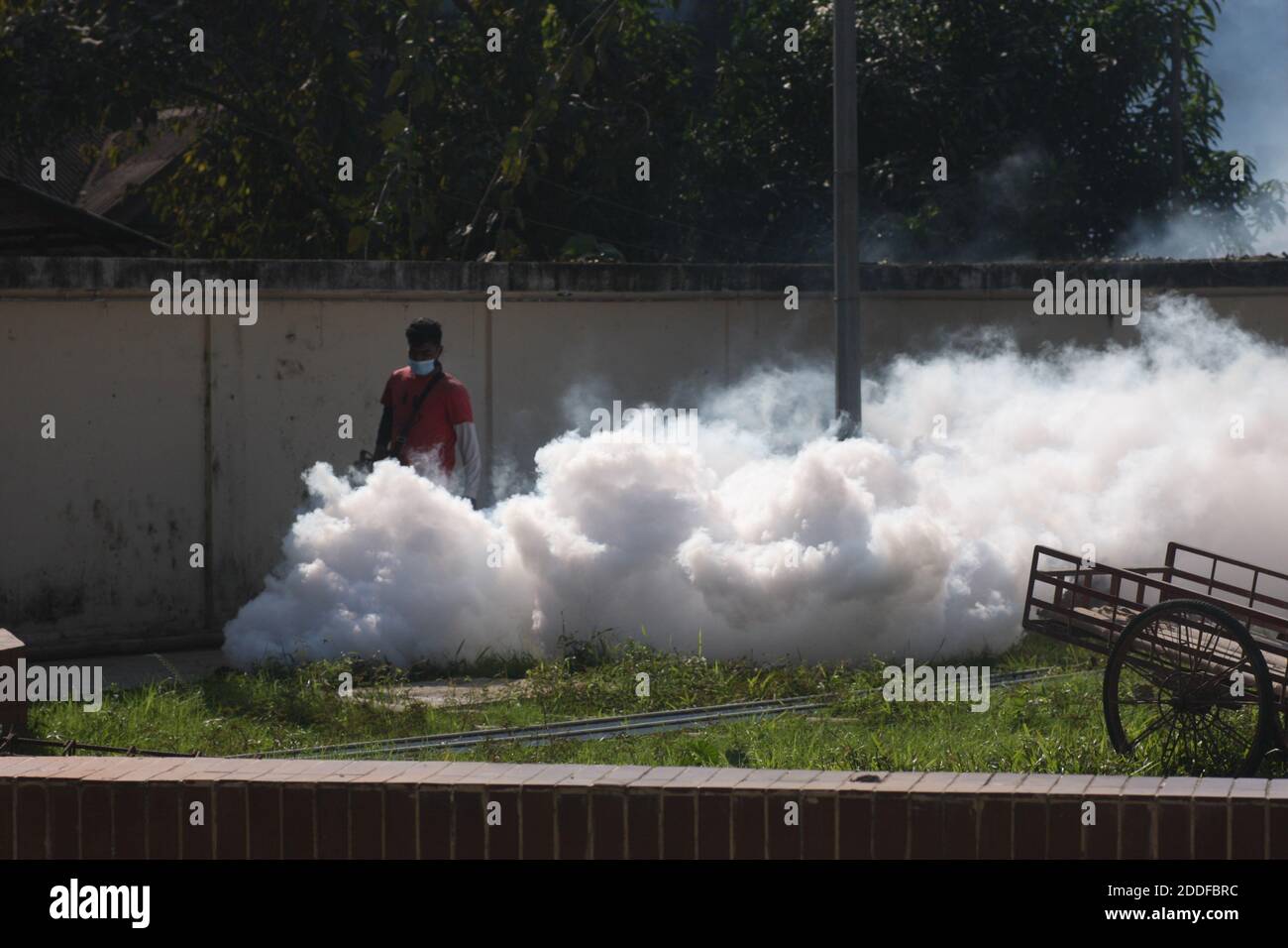 An employee of Sylhet City Corporation is spraying pesticides to kill mosquitoes. Stock Photo
