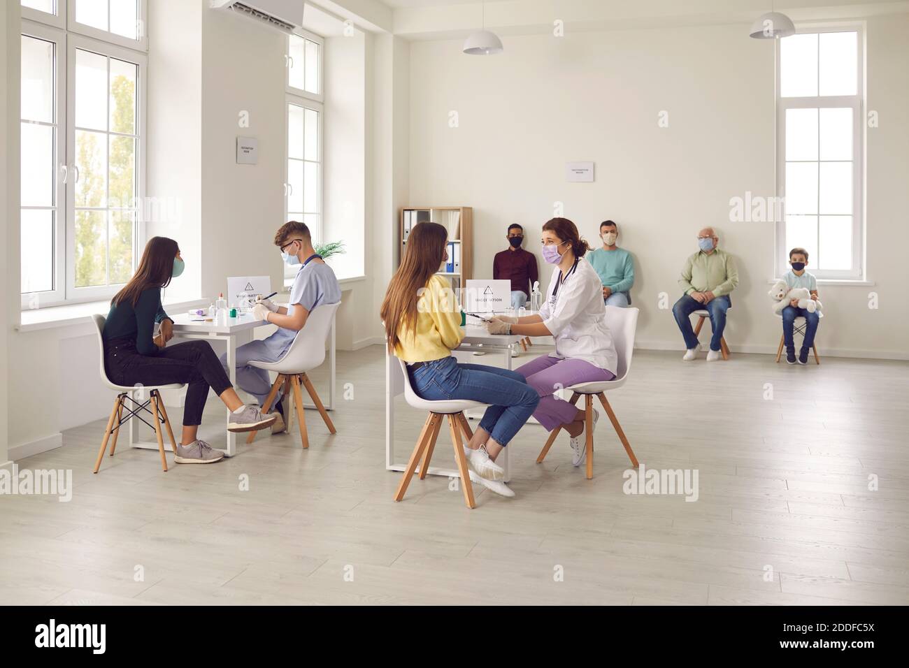 Diverse people talking to doctors before getting an antiviral injection at the hospital Stock Photo