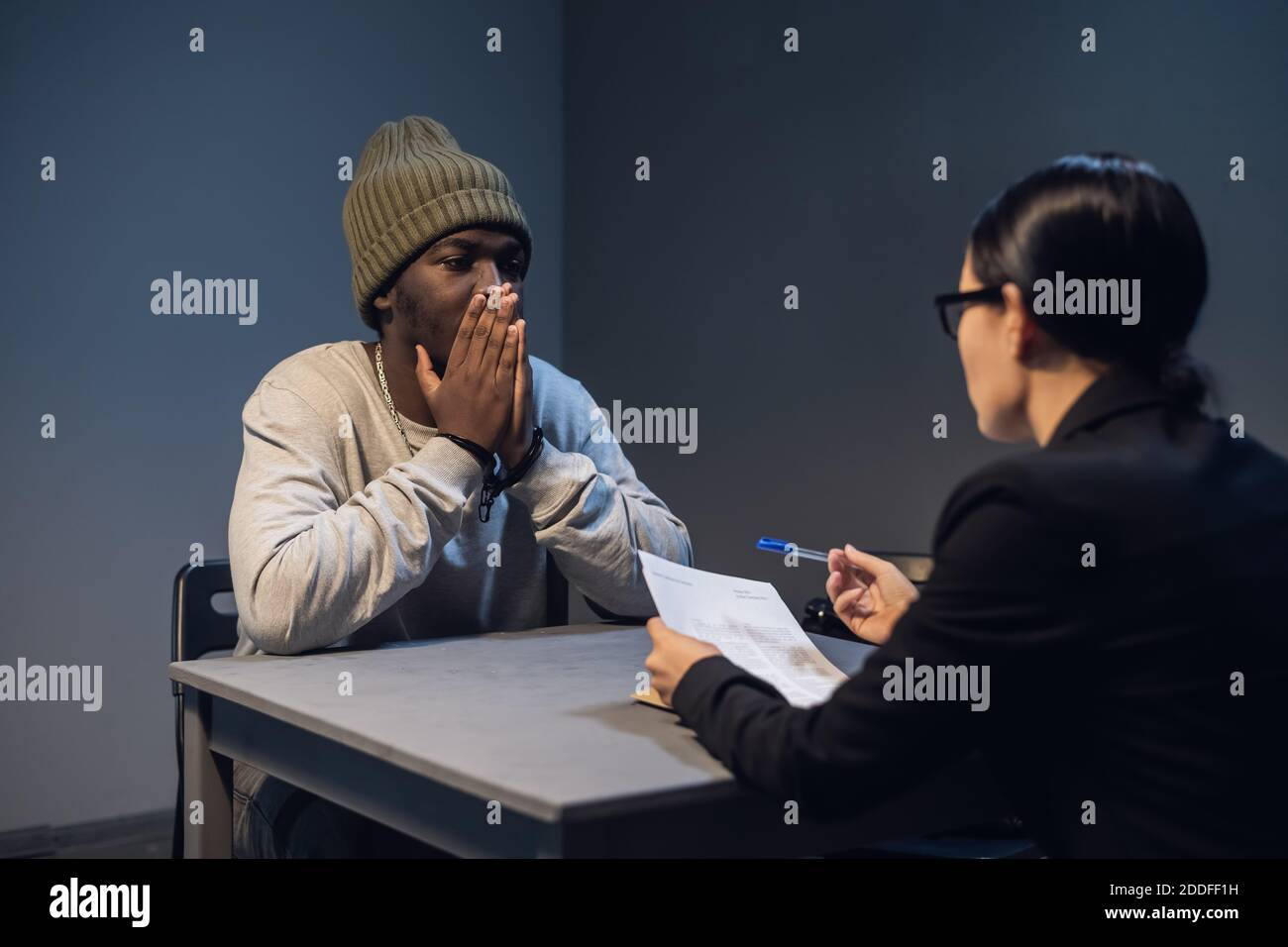 A black guy listens to his rights from a civil lawyer at a table in a