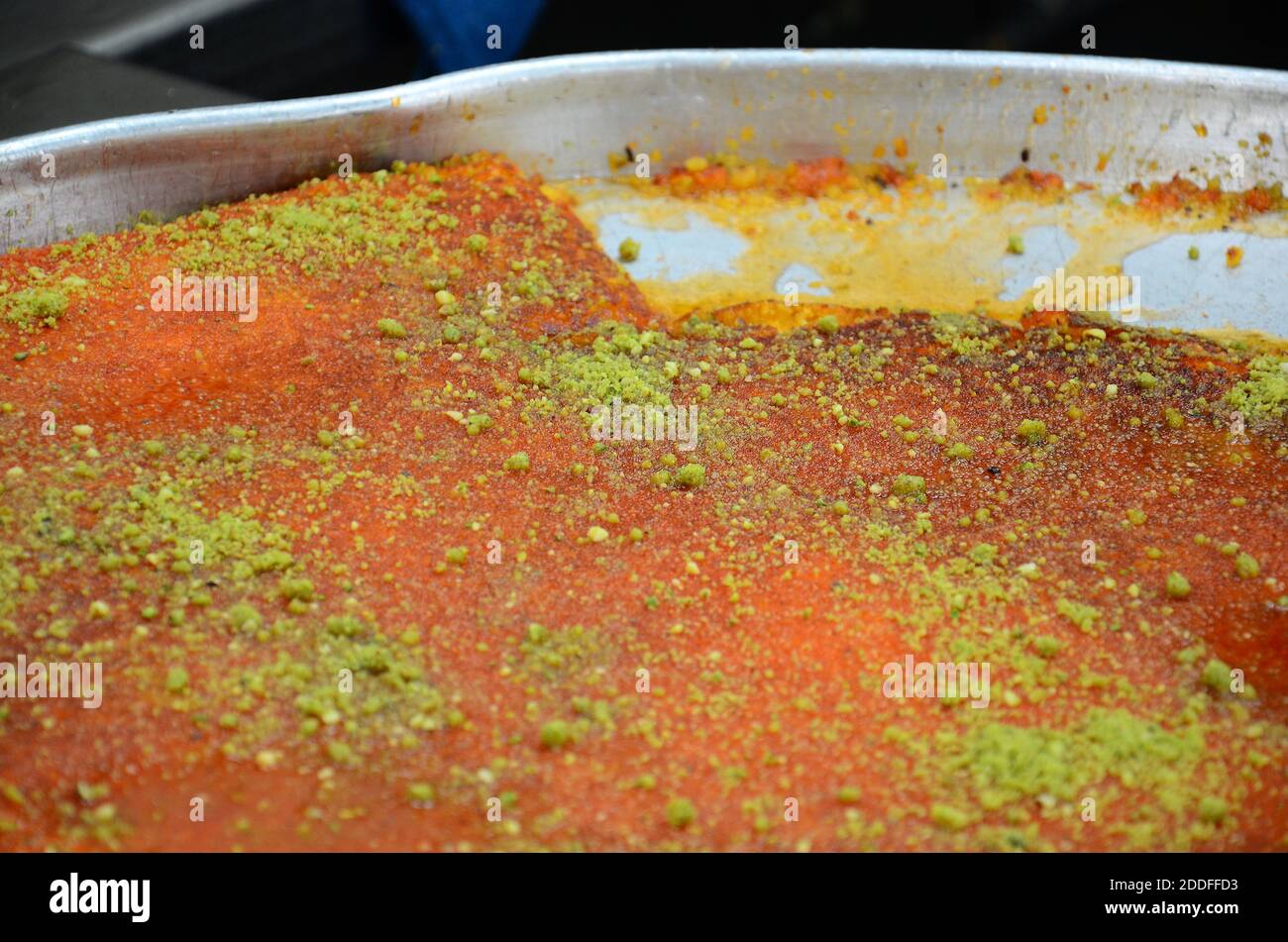 Kanafeh, traditional Middle Eastern dessert made with cheese, in a  siniyyeh large metal tray. Amman, Jordan Stock Photo