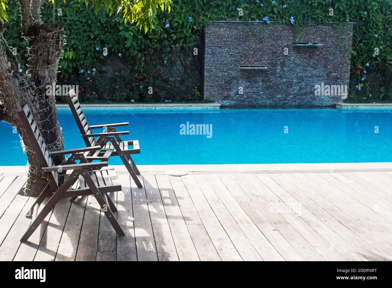 Swimming pool with two empty chairs Stock Photo