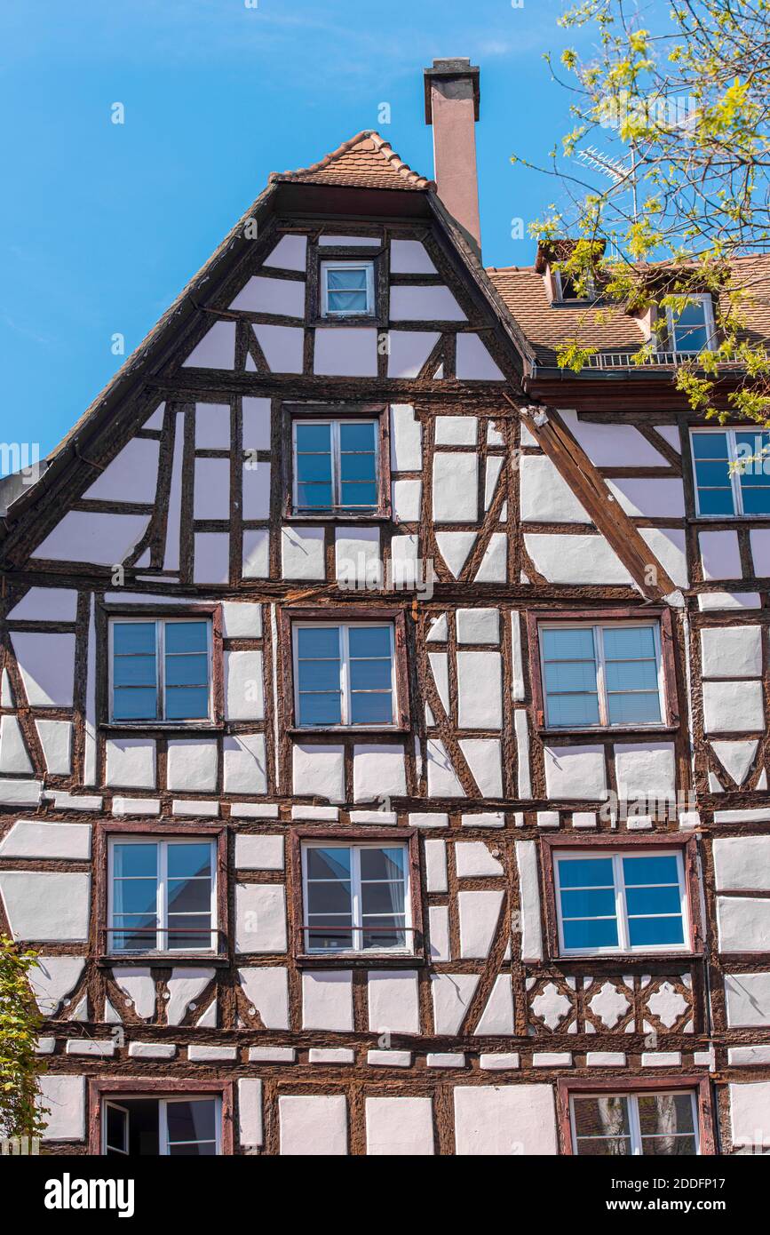 Natural half timbered old house in France, Strasbourg. Half timbered style. Facade of the historical wooden building during sunny spring day. Stock Photo