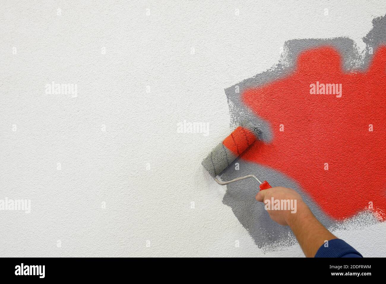 painting walls with a roller in his left hand Stock Photo Alamy