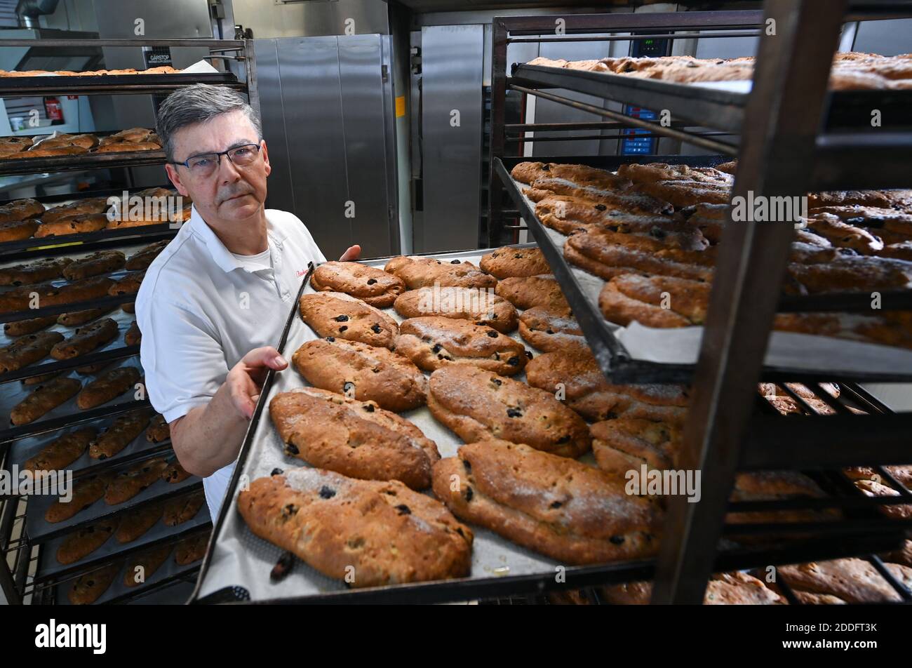 19 November 2020, Saxony-Anhalt, Klosterhäseler: Master baker Rolf Block transports freshly baked Naumburg Stollen in his bakery in Klosterhäseler. Around 5000 pieces of the traditional Christmas cake leave the bakery this year. The Corona pandemic is also having an effect here, so the café of the bakery and confectionery is currently closed, but the online shop is doing much better. The special feature of his Naumburg Stollen are the dried and kirsch-soaked sweet cherries, which are added to the dough in place of the sultanas. Photo: Hendrik Schmidt/dpa-Zentralbild/ZB Stock Photo