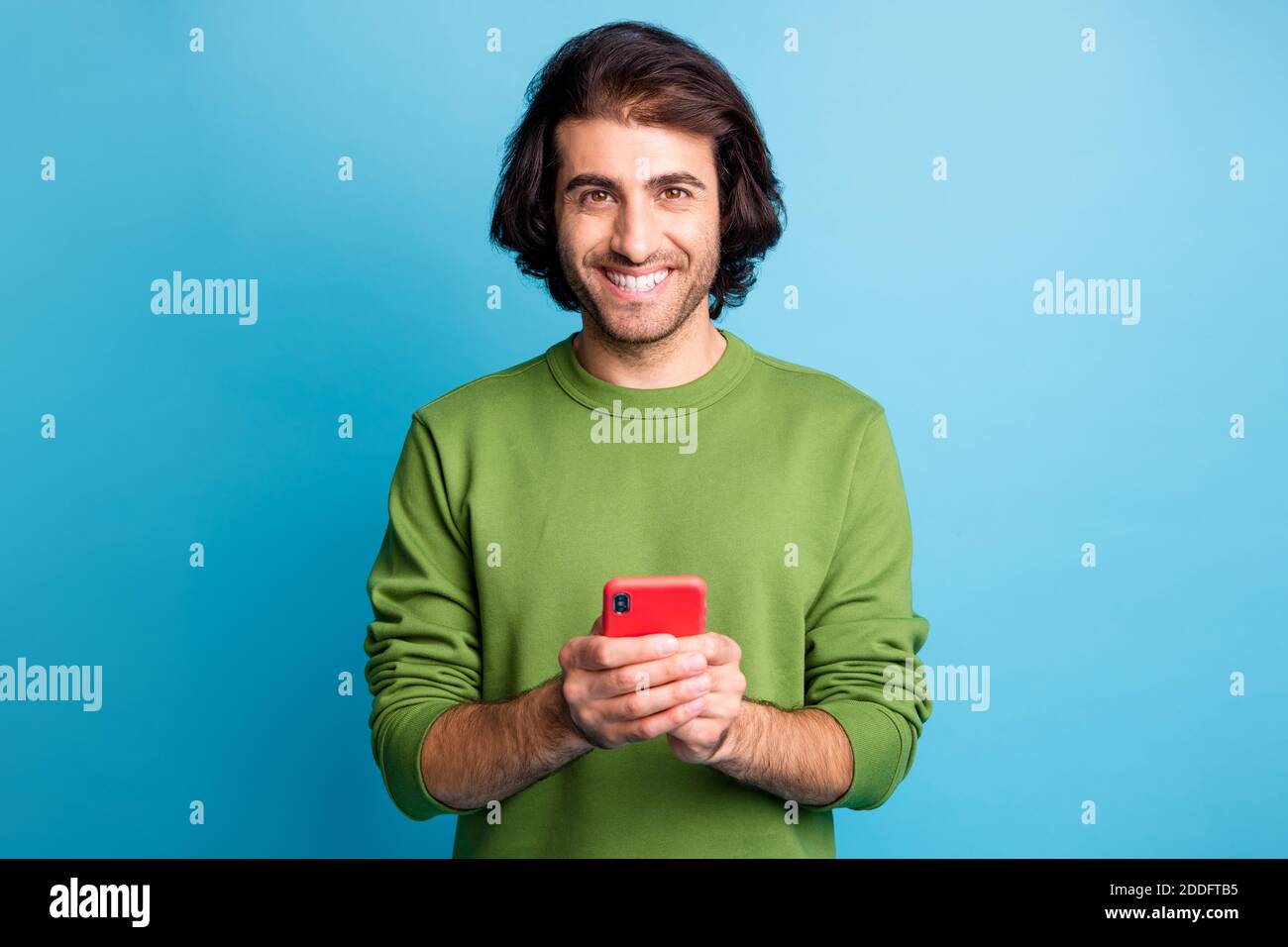 Portrait of toothy smile man hold phone read good news nice pullover ...