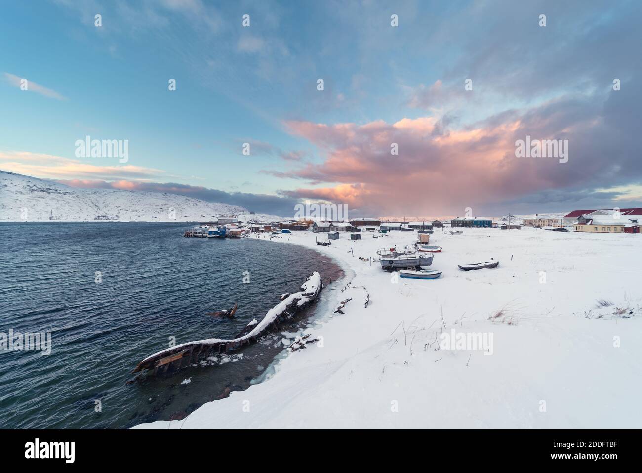 View of the old Russian fishing village of Teriberka with a shipwreck at the mouth of the namesake river on the Barents Sea, well above the Arctic cir Stock Photo