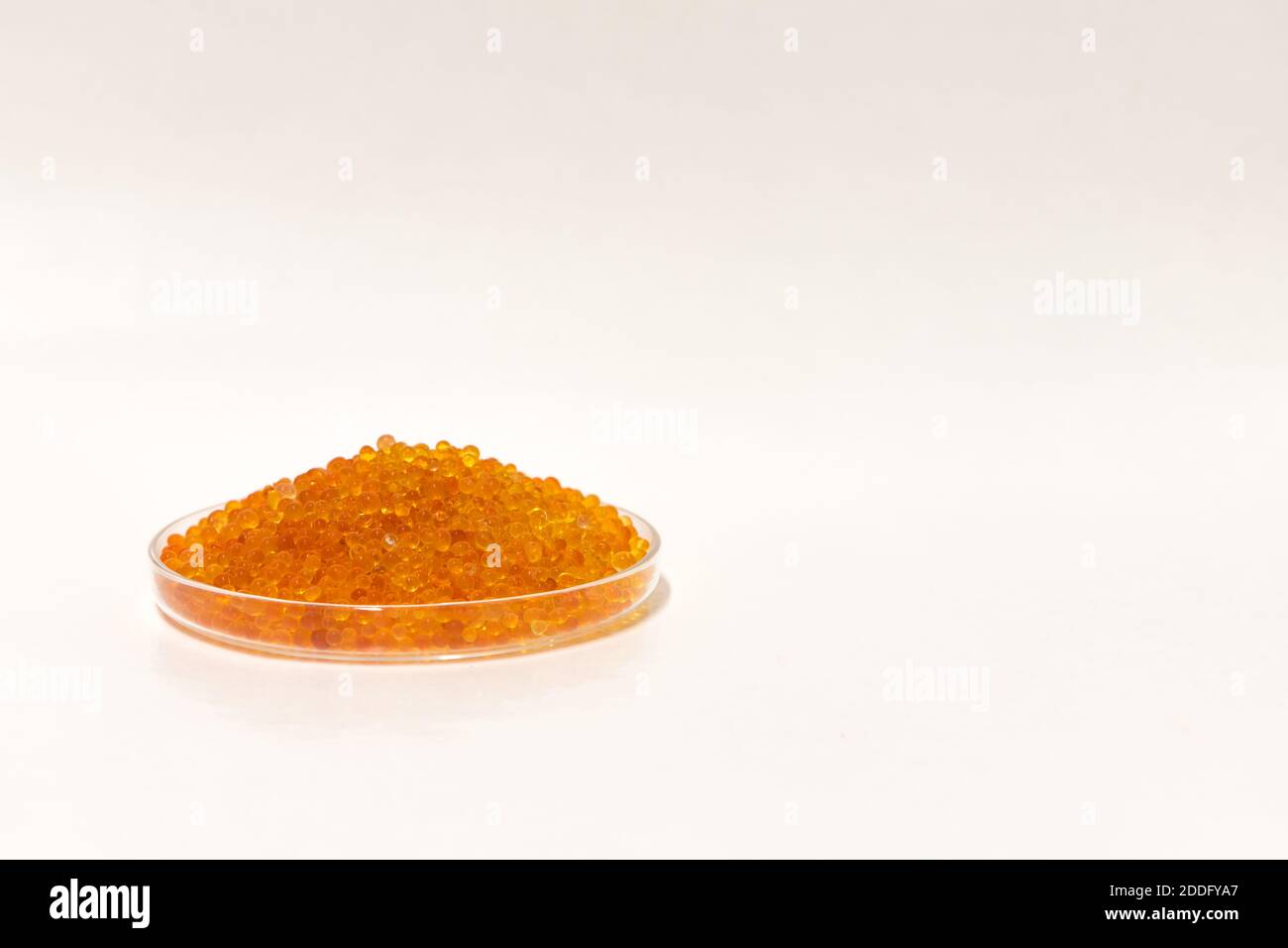 Silica gel dessicant on a white background. Small golden beads in a