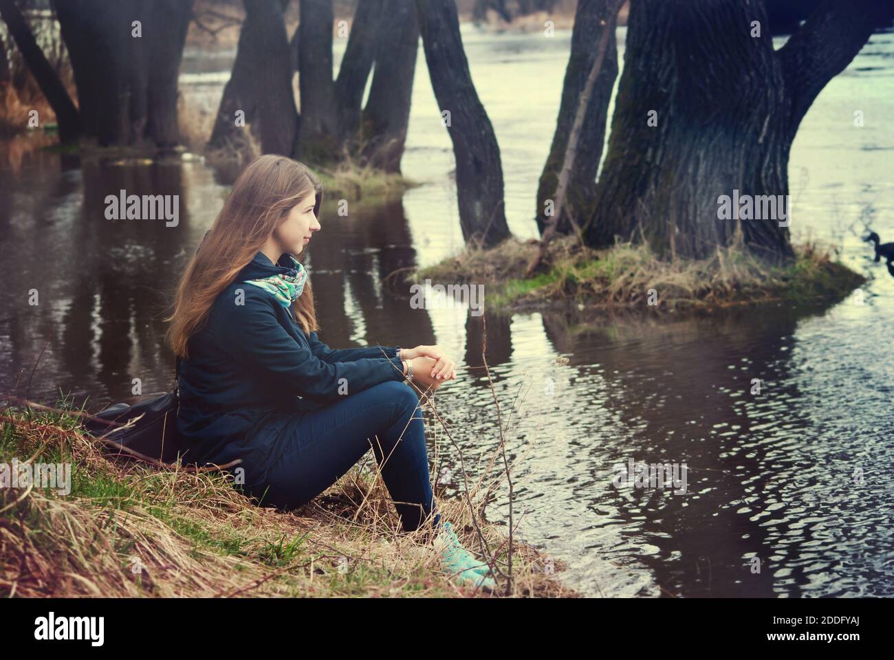The girl sits on the river bank Stock Photo - Alamy