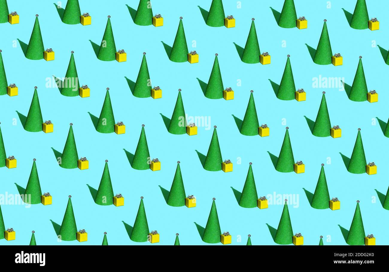 Christmas pattern of green Christmas trees in the form of a cone and a small gift on a blue background Stock Photo