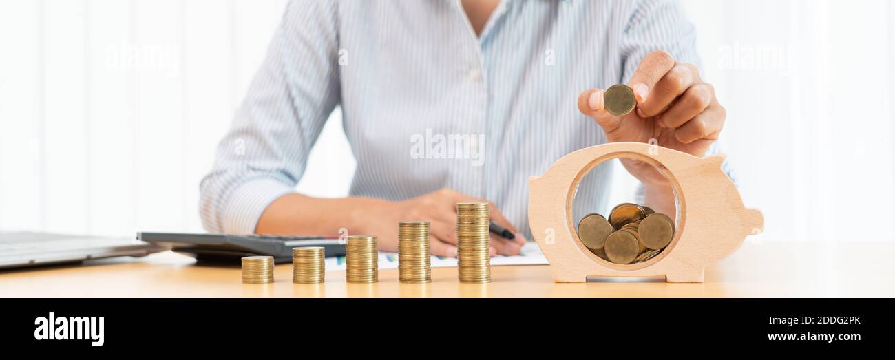 woman hand putting money coin into piggy bank with step of growing ...