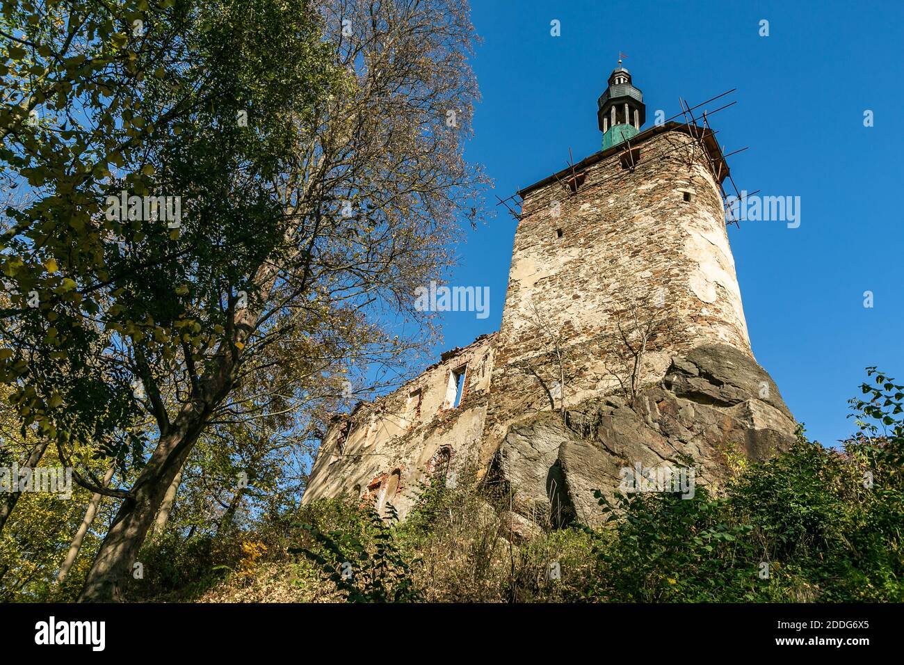 Hartenberg, Czech Republic - October 14 2018: View of a tower as a part of the ruined gothic castle in reconstruction standing on a rock. Trees around. Stock Photo