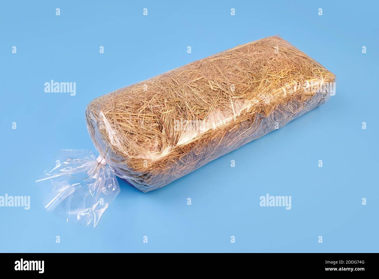 Pack of hay for guinea pigs in plastic bag in blue table. Bedding hay