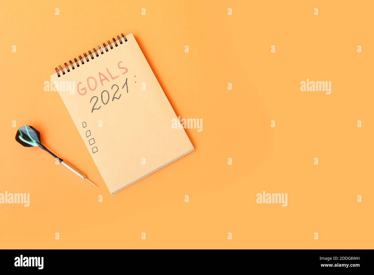 Notebook with empty todo list and dart on color background Stock Photo