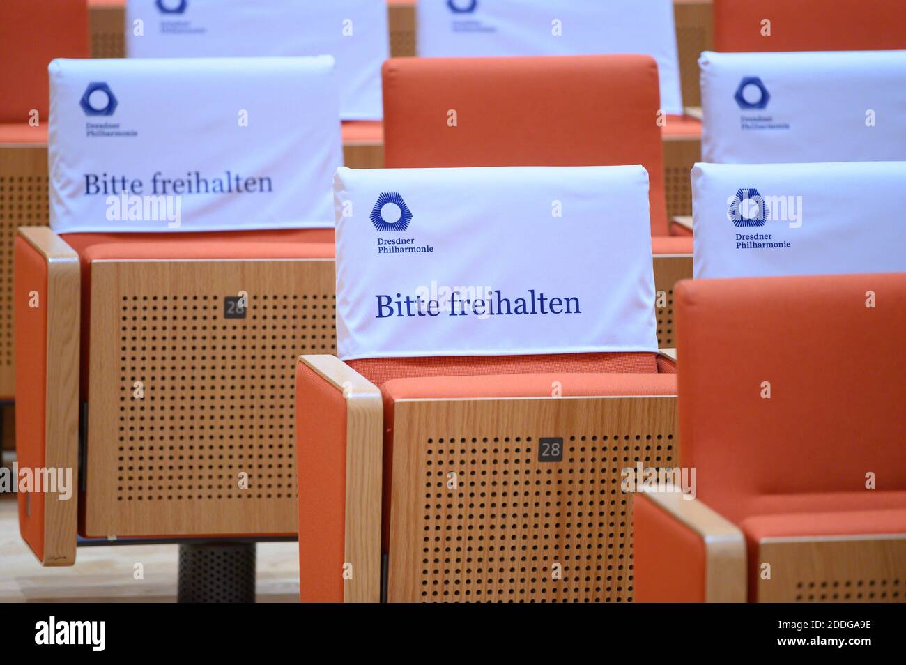 25 November 2020, Saxony, Dresden: Covers with the inscription 'Please keep clear' are hanging over some empty chairs in the auditorium of the Kulturpalast on the edge of a press conference. The occasion is the extension of the contract of the chief conductor of the Dresden Philharmonic Orchestra. Photo: Sebastian Kahnert/dpa-Zentralbild/dpa Stock Photo