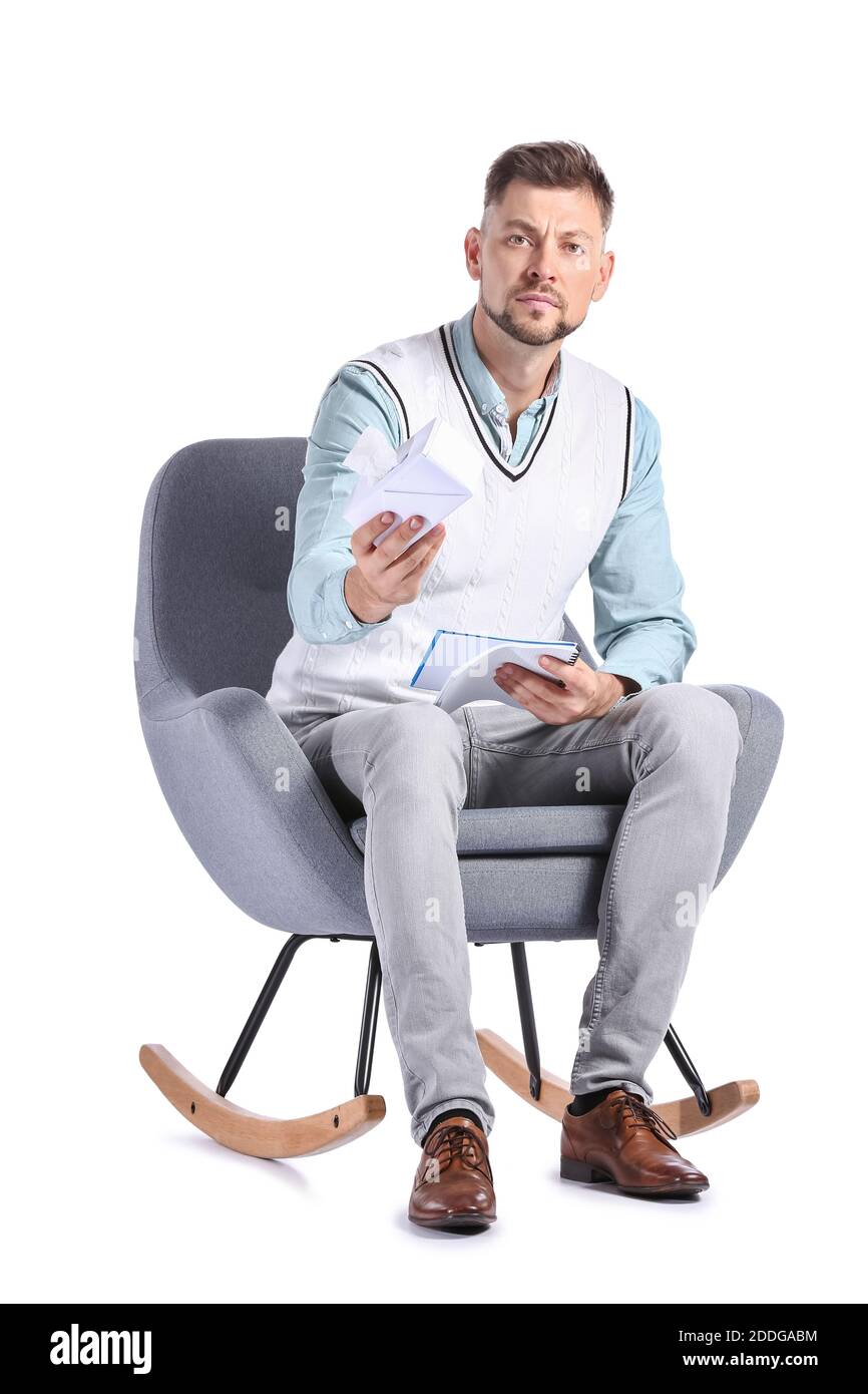 Male psychologist with tissues sitting in armchair on white background