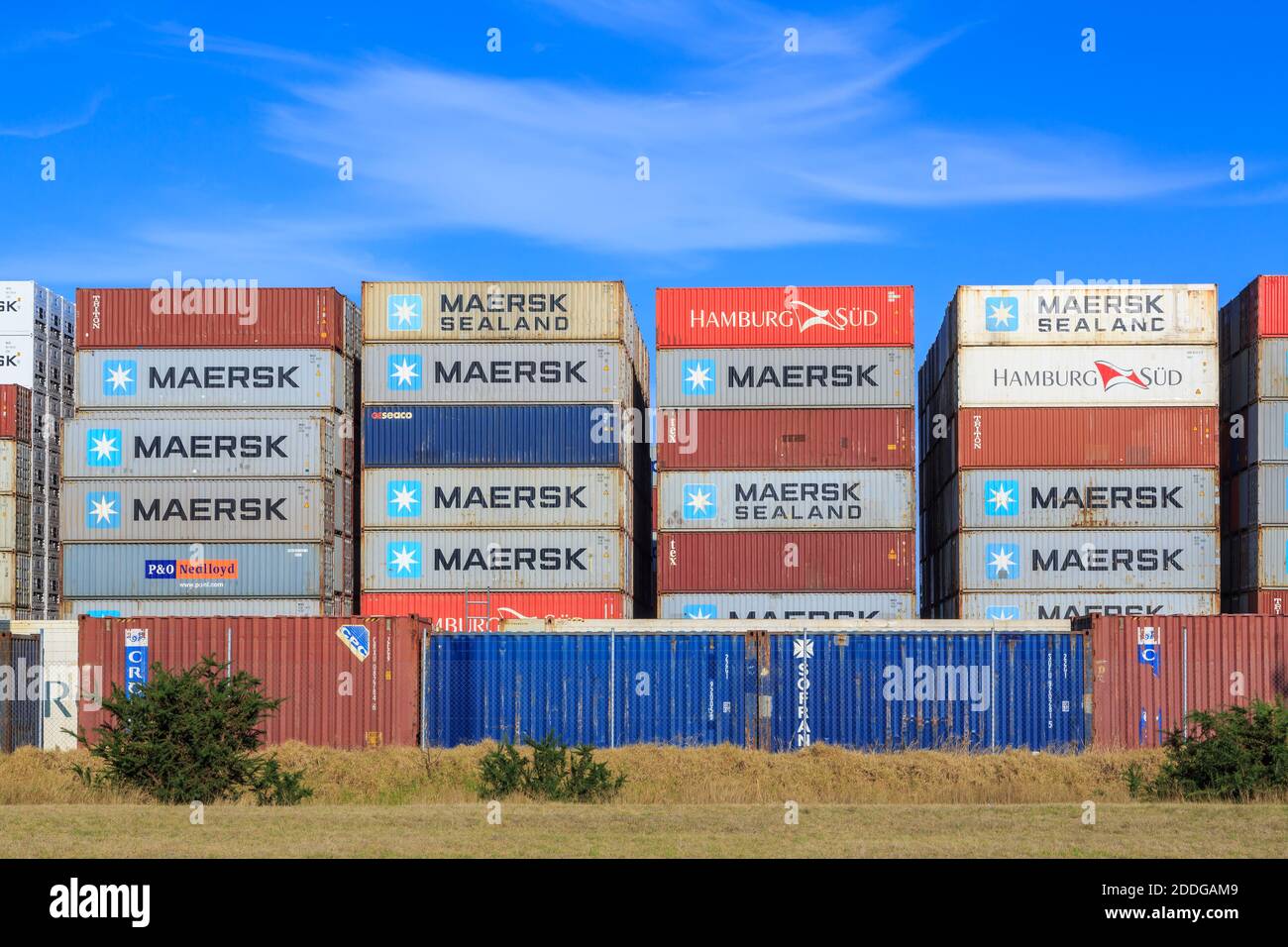 Stacks of shipping containers with the logos of various companies in an