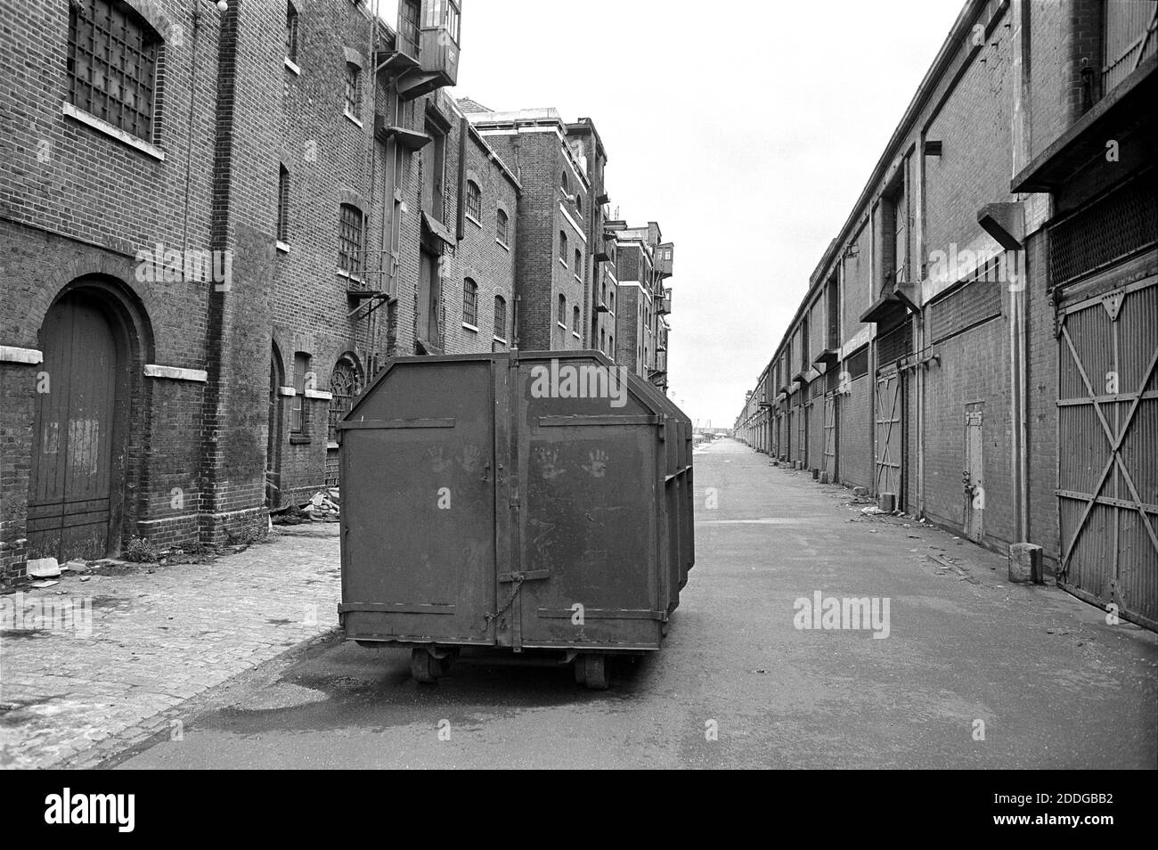 UK, London, Docklands, Isle of Dogs, early 1974. Import warehouses, West India Docks (north). Handprints on the rubbish cart. The long strip of warehousing on the right has now been demolished.This area is now (2020) home to The Museum of Docklands (just behind the camera position) & various restaurants at Hertsmere Road, E14 4AL Stock Photo