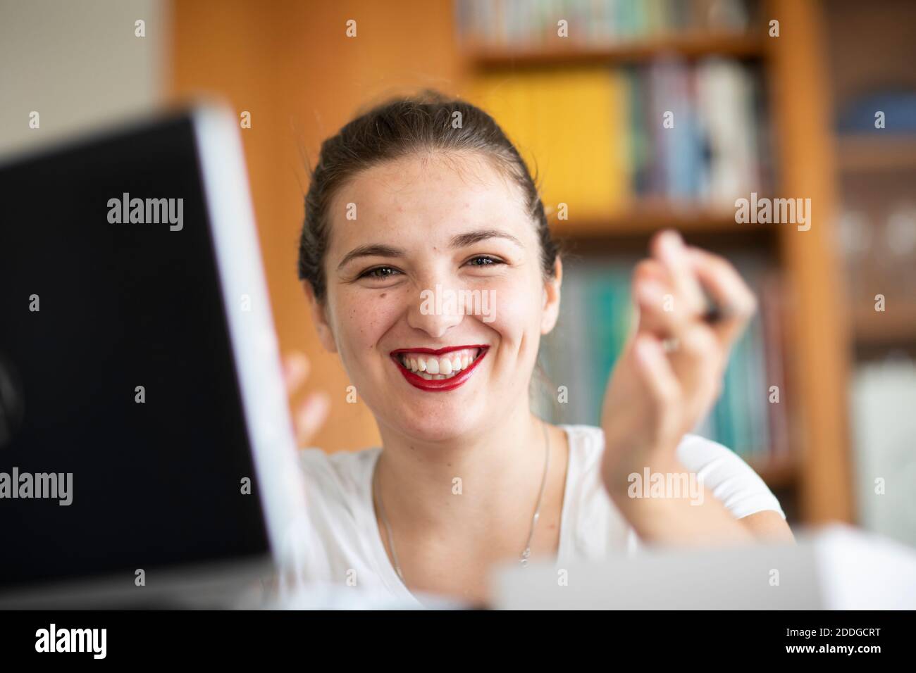 Young woman at computer in library, smiling Stock Photo
