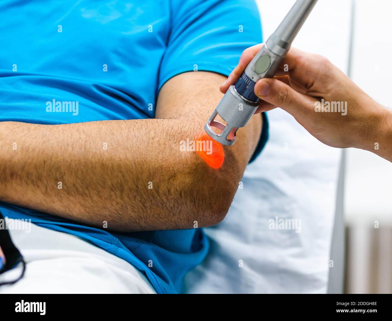 Unrecognizable cropped doctor using laser probe to heal elbow of crop ...
