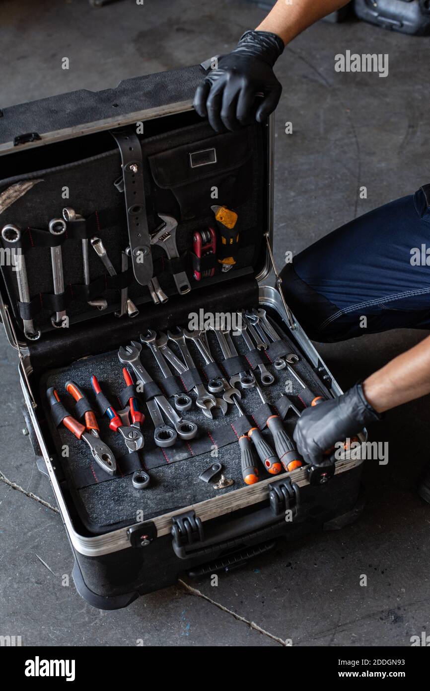 From above unrecognizable male technician picking screwdriver bits from tool box while working in garage Stock Photo