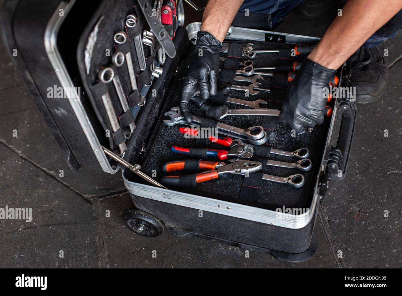 From above unrecognizable male technician picking screwdriver bits from tool box while working in garage Stock Photo
