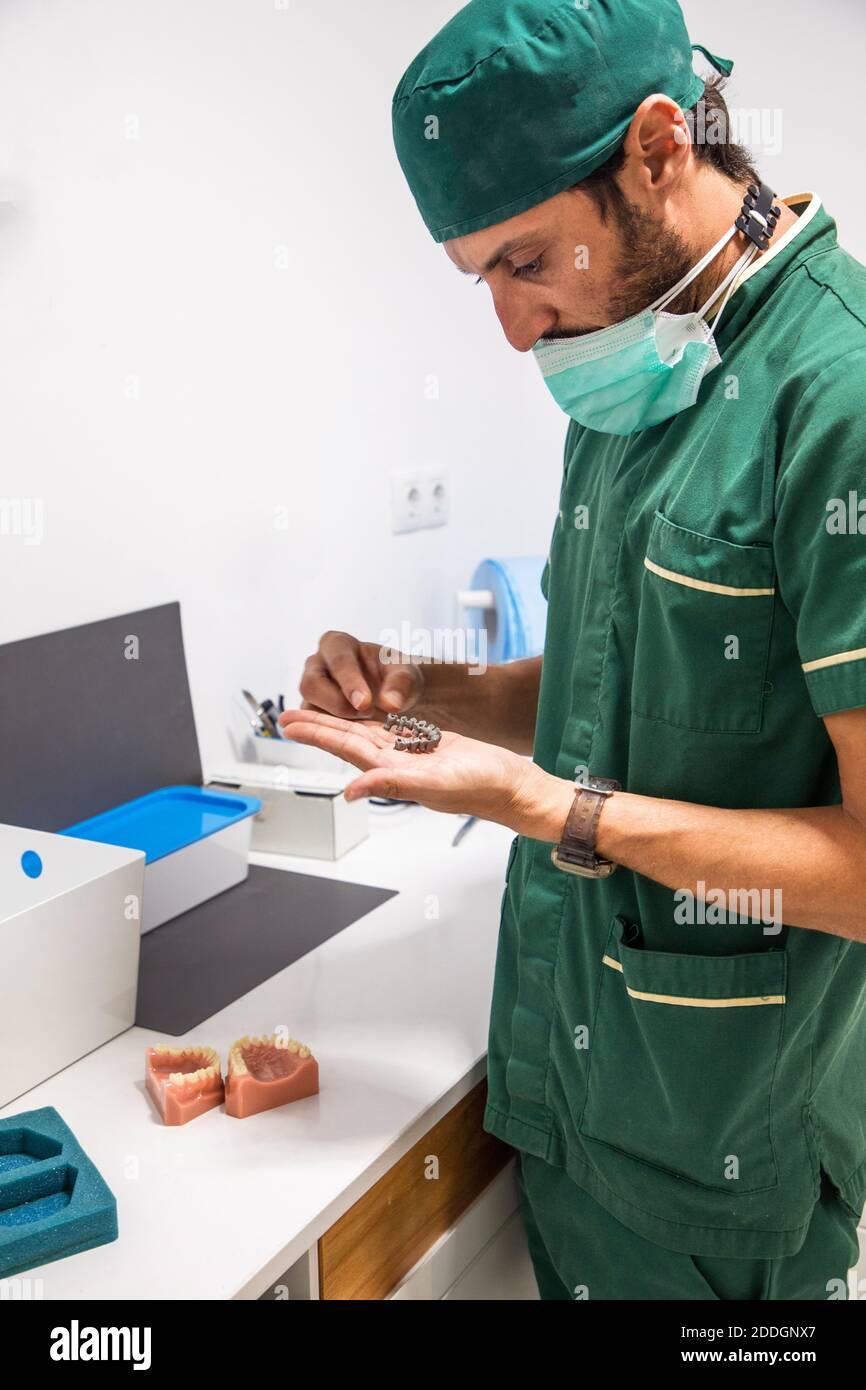 Side view of dentist holding gray dental plaster cast in dentistry
