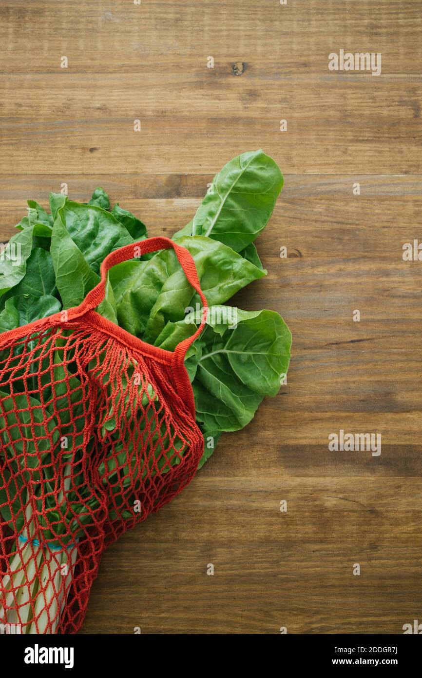 Top view of fresh vegetable in cotton eco friendly sacks placed on wooden table Stock Photo