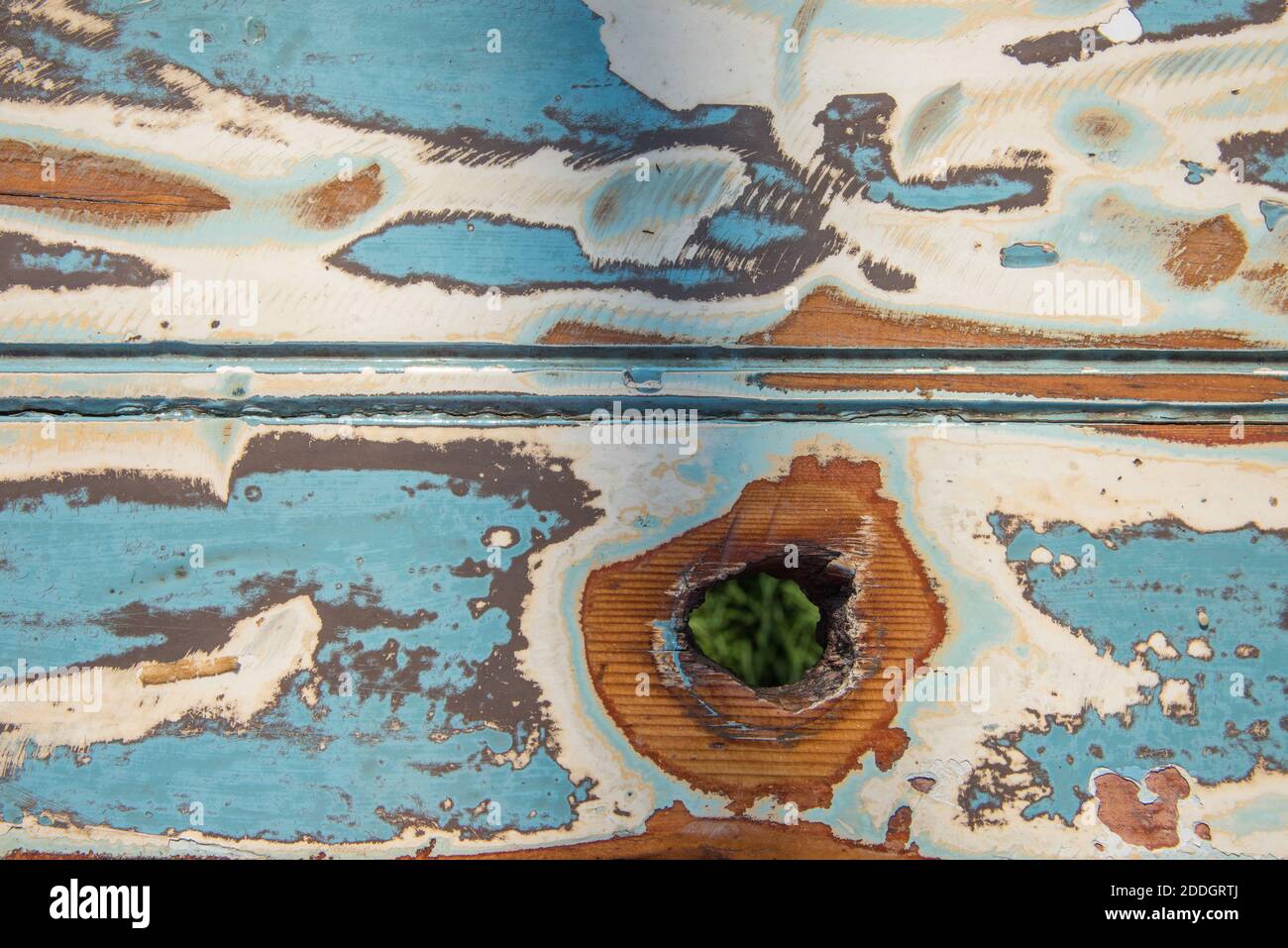 High angle view over shabby chic painted picnic table surface in full frame detail with baby blue, cream and brown coloring. Stock Photo