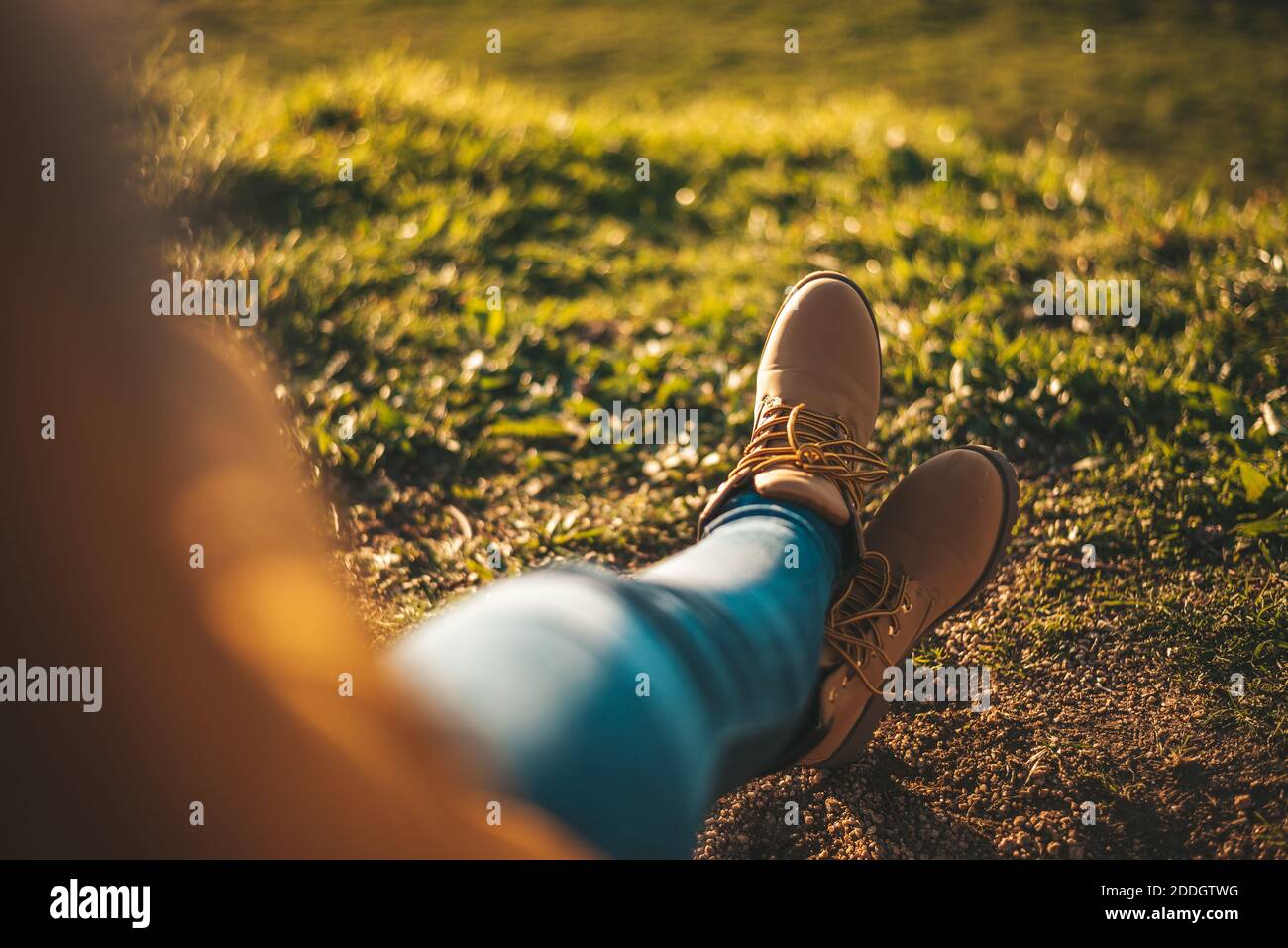 Detail of some feet with boots relaxing against grass Stock Photo - Alamy