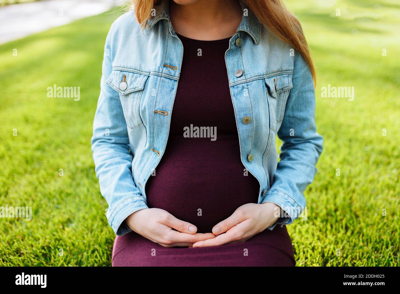 macro photo, pregnant woman hugs belly in park Stock Photo - Alamy