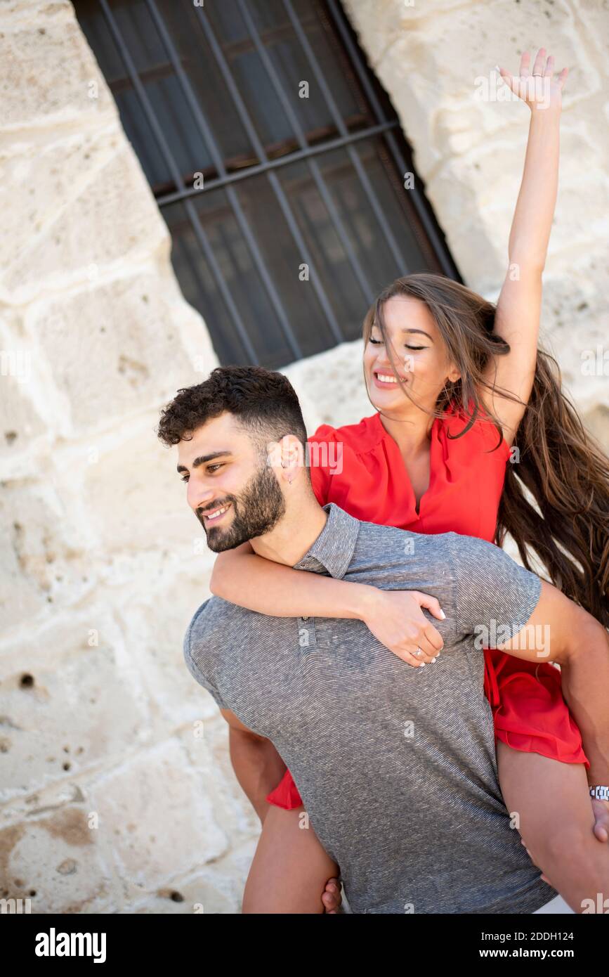 Portrait of a happy young couple enjoying a piggyback ride Stock Photo ...