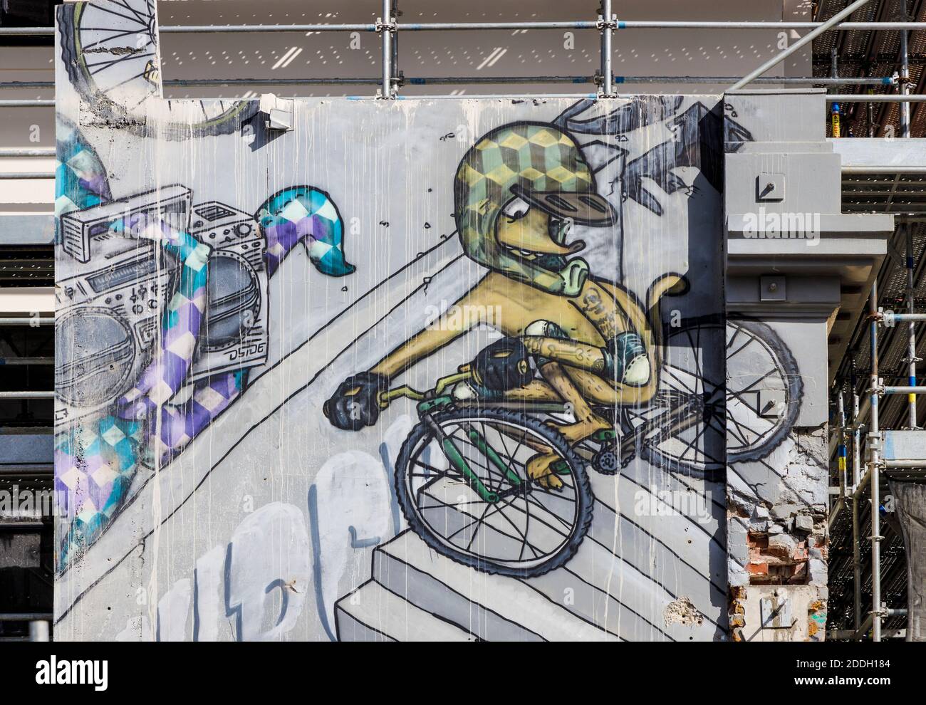 Cartoon figure on a bike. Large canvas panel partly removed during earthquake restoration work, Christchurch, New Zealand. Stock Photo