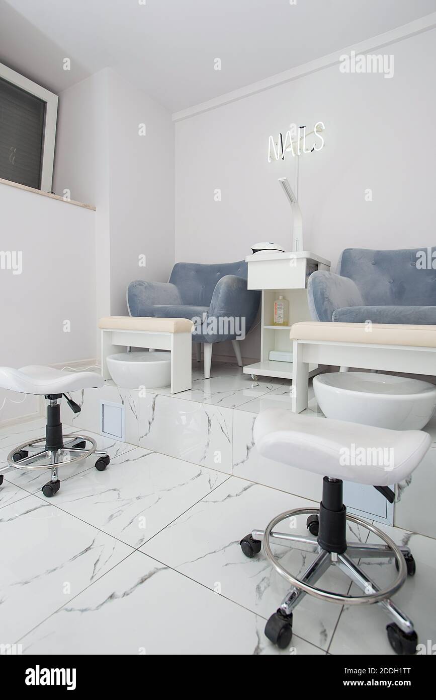 Interior of white modern manicure salon without people. Luxury work places for masters of pedicure Stock Photo