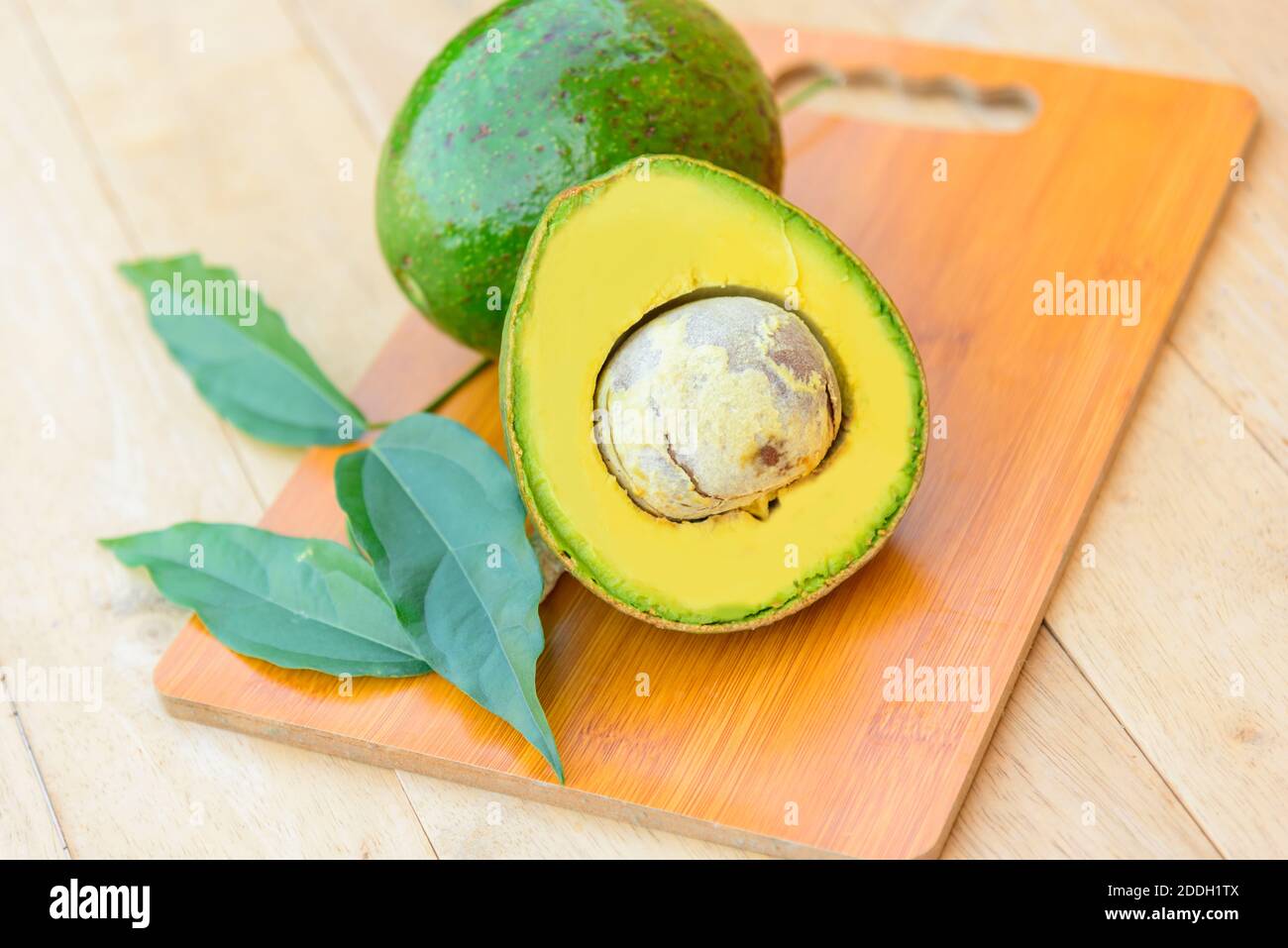 Fresh avocado split on the wood plate Stock Photo - Alamy