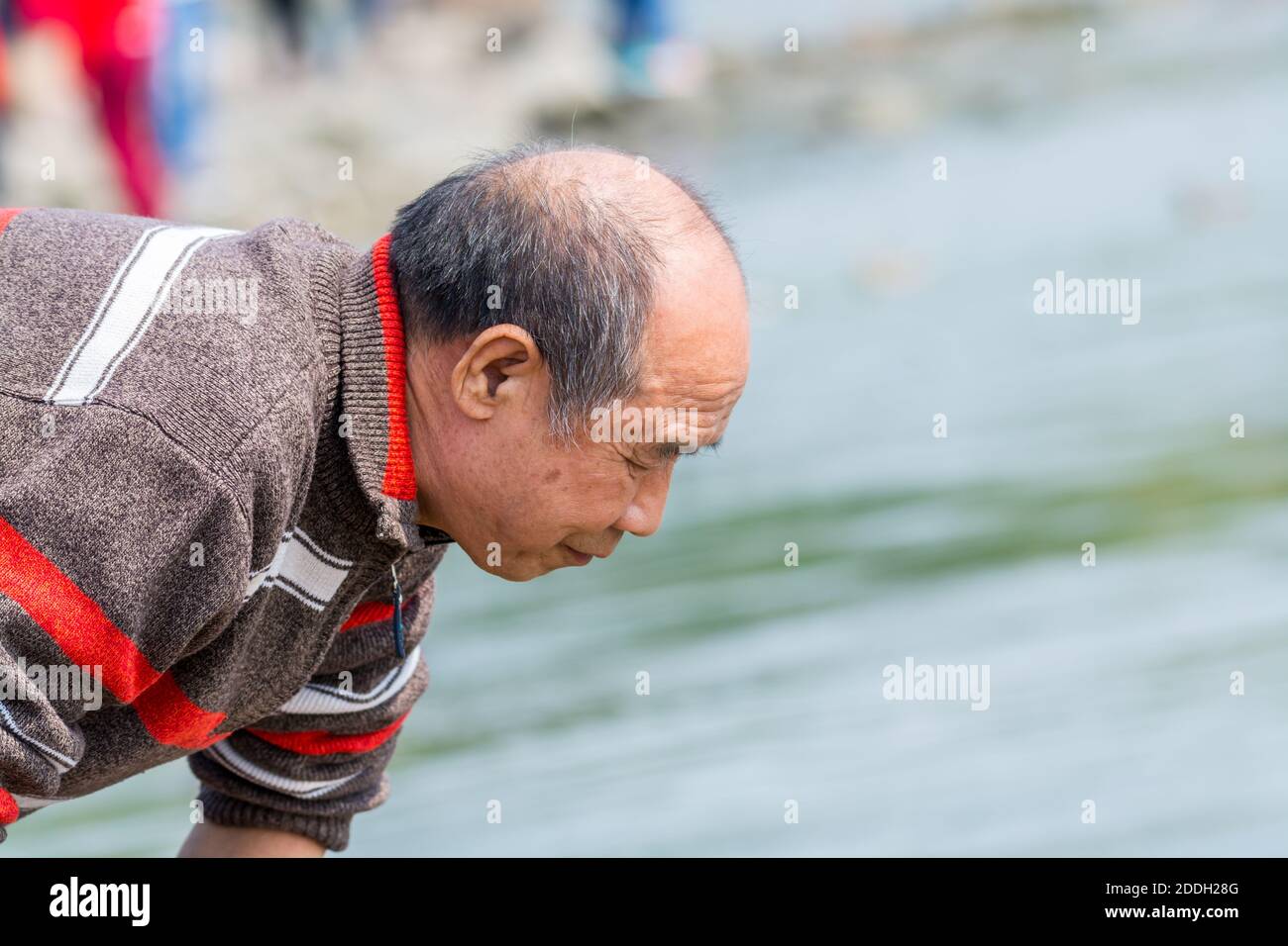 A Chinese old man finding fish at the river at the Shenzhen Bay of China  during weekend Stock Photo - Alamy