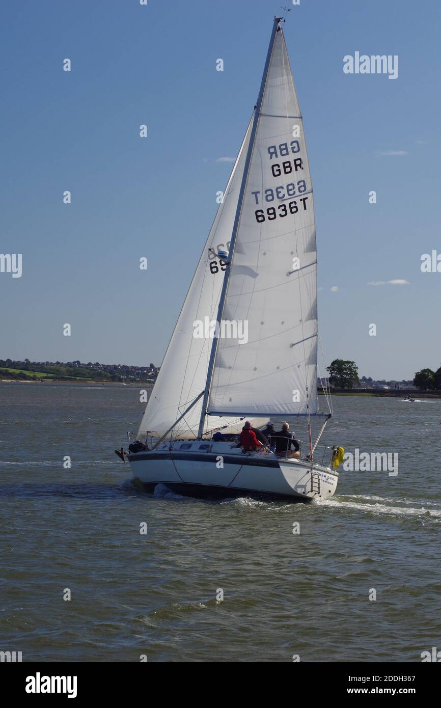 Leaning Dynamic Yacht Sailing on the Exe Estuary by Turf Lock on a sunny autumn day. Devon, UK. Stock Photo