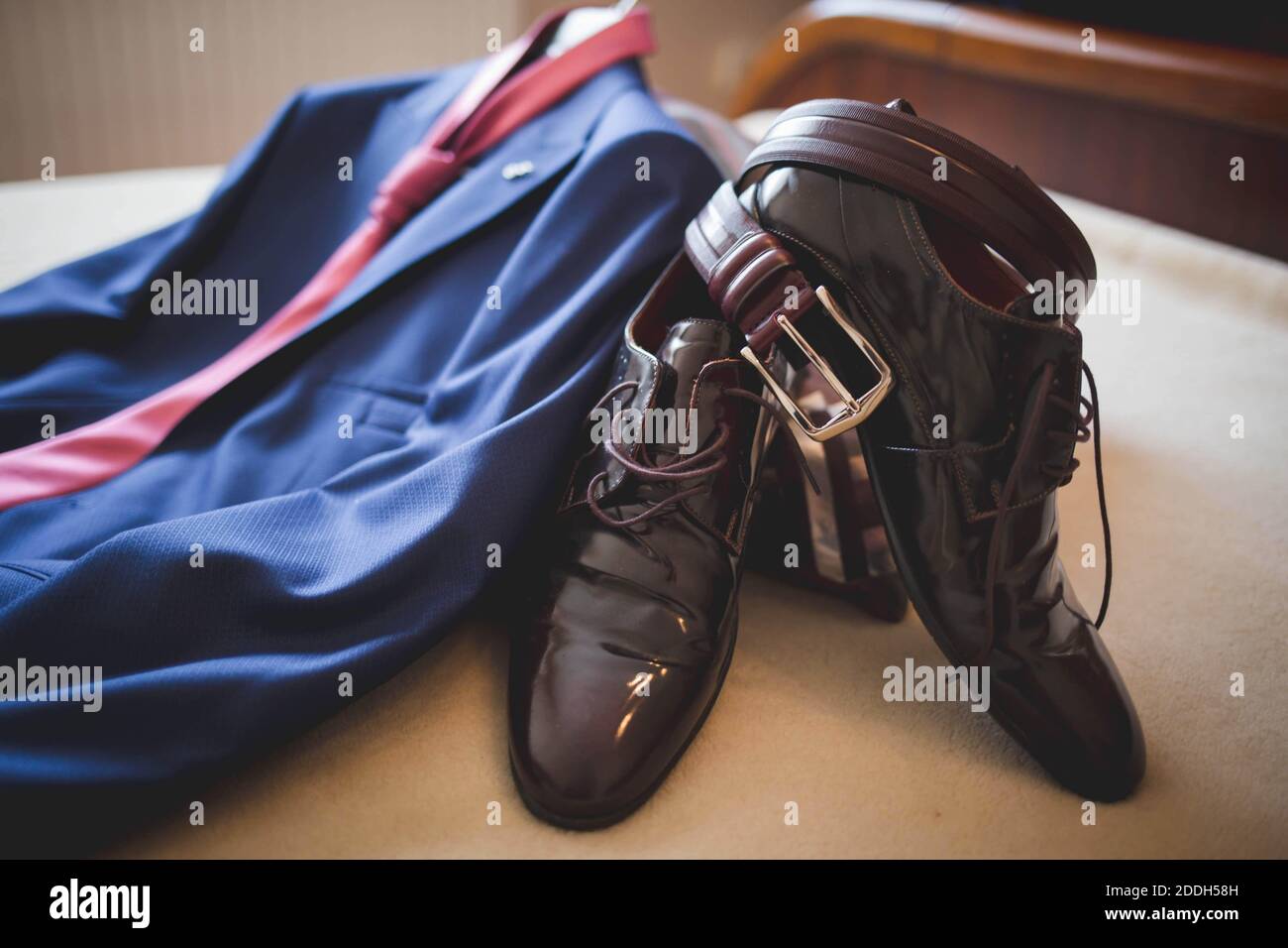 a blue suit with a red tie and brown shoes with a belt Stock Photo - Alamy