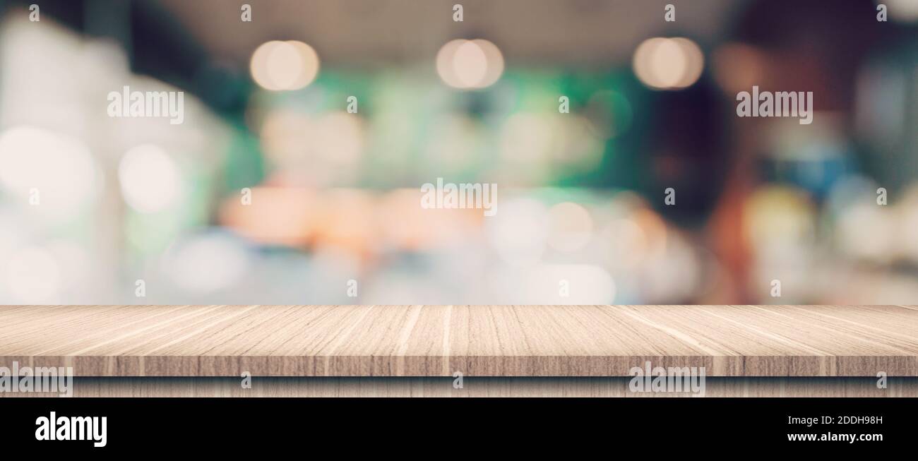 Empty wood table and blurred light table in coffee shop and cafe with ...