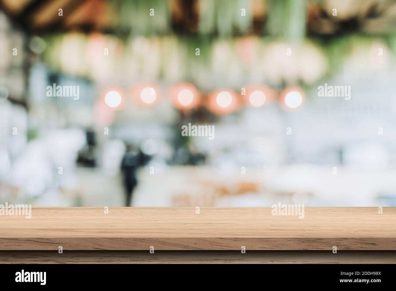 Empty wood table and blurred light table in coffee shop and cafe with ...
