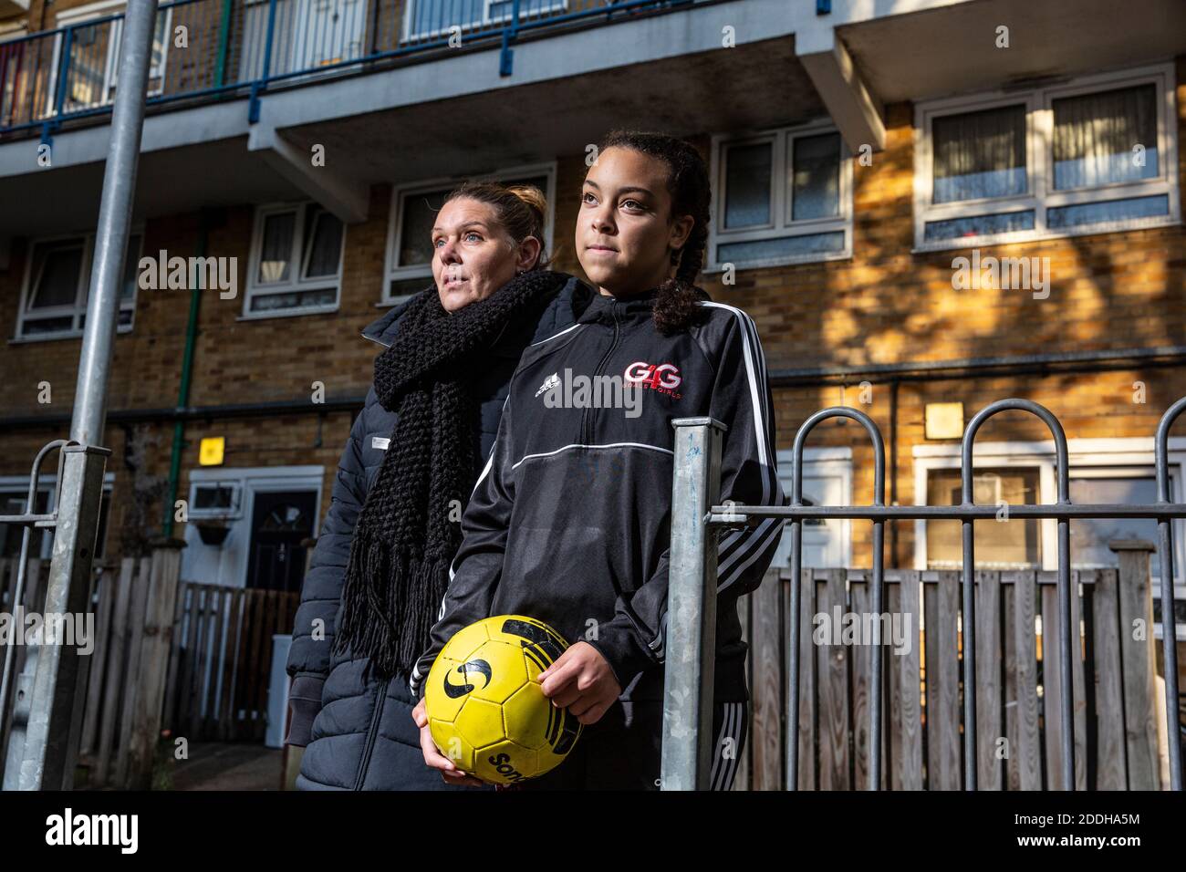 Teenage girl outside her home after school playing football after a national coronavirus lockdown stopped her playing for her Saturday football team. Stock Photo