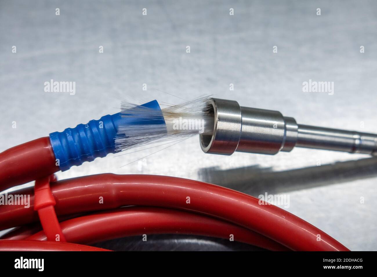 a broken red fiber optic cable lies on a silver base Stock Photo Alamy