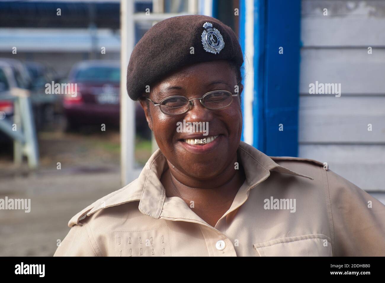 A local woman security guard with a beaming smile and two gold front teeth, poses at the port entrance to Georgetown, Guyana, South America Stock Photo