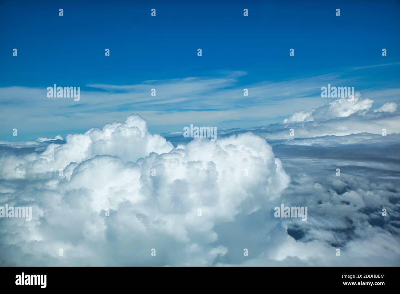 An aerial shot of white fluffy cumulus clouds from above with a blue ...
